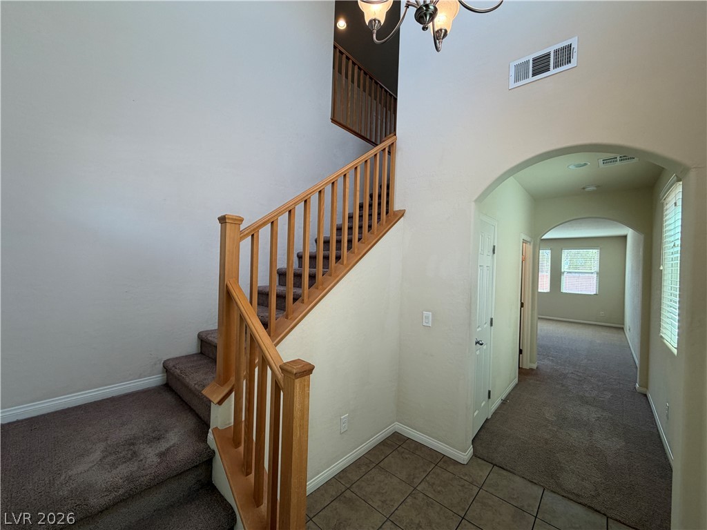 442 White Heart Road Las Vegas, NV 89148 - Photo 2 of 25 High ceilings and a wood-railed staircase welcome guests into the tiled entry foyer.