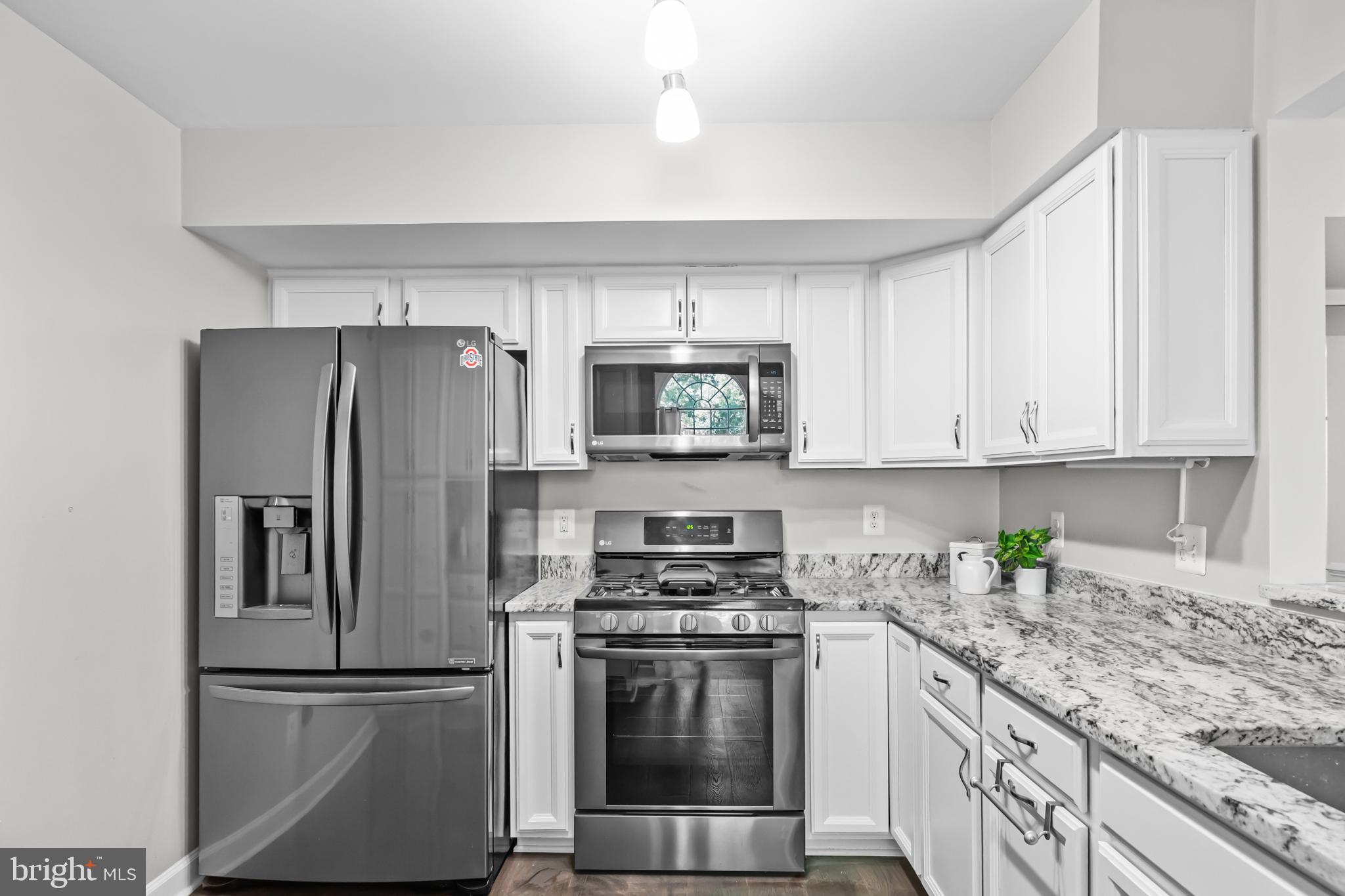 17045 Islip Loop, Unit 303 Dumfries, VA 22026 - Photo 16 of 48 a kitchen with cabinets stainless steel appliances and a counter space