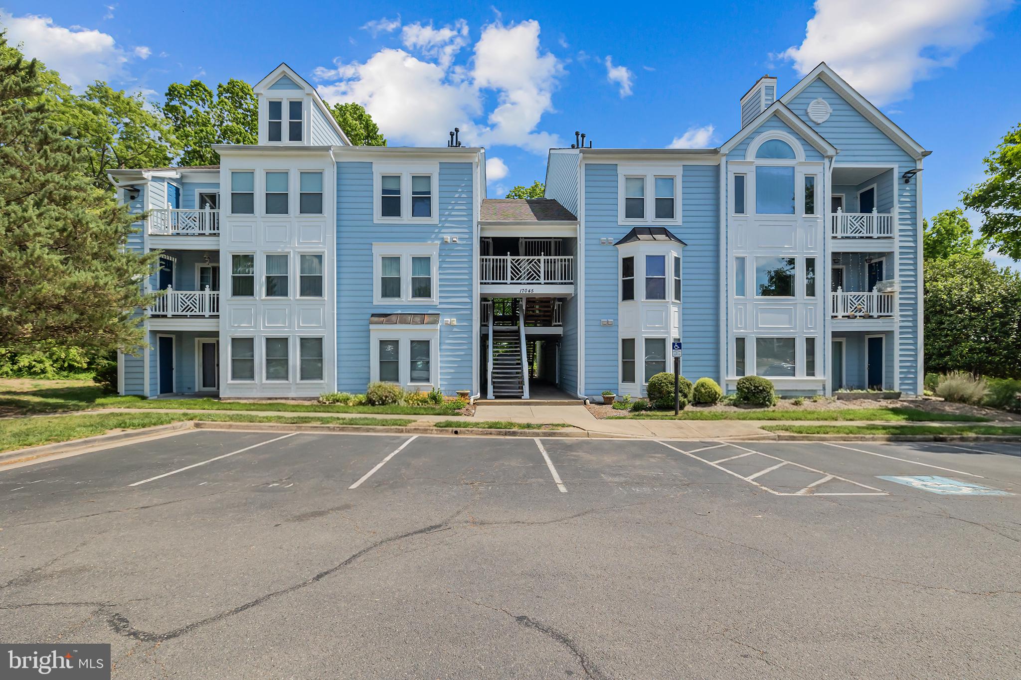 17045 Islip Loop, Unit 303 Dumfries, VA 22026 - Photo 2 of 48 a front view of a residential apartment building with a yard