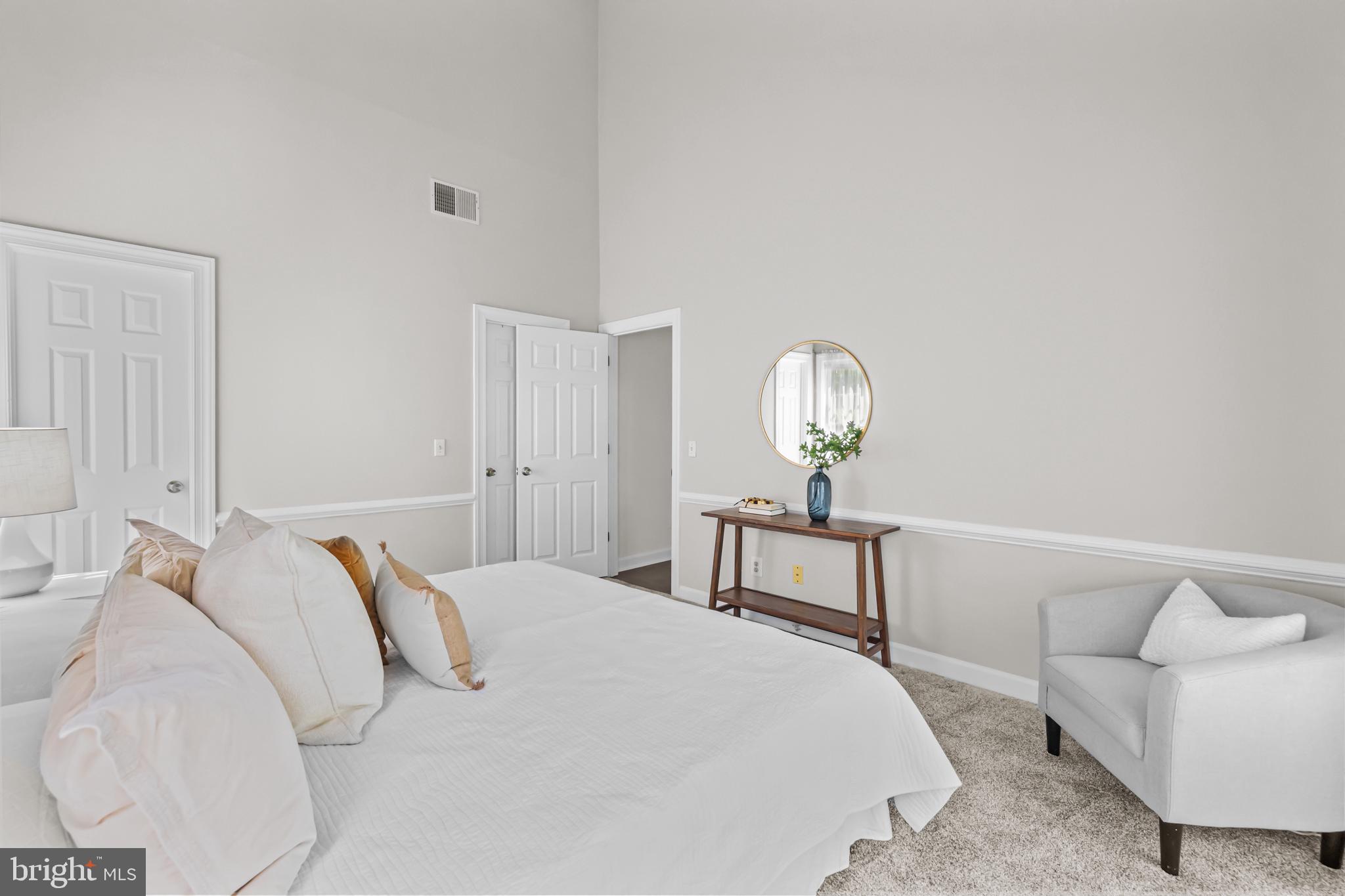 17045 Islip Loop, Unit 303 Dumfries, VA 22026 - Photo 21 of 48 a bedroom with a bed table and chair