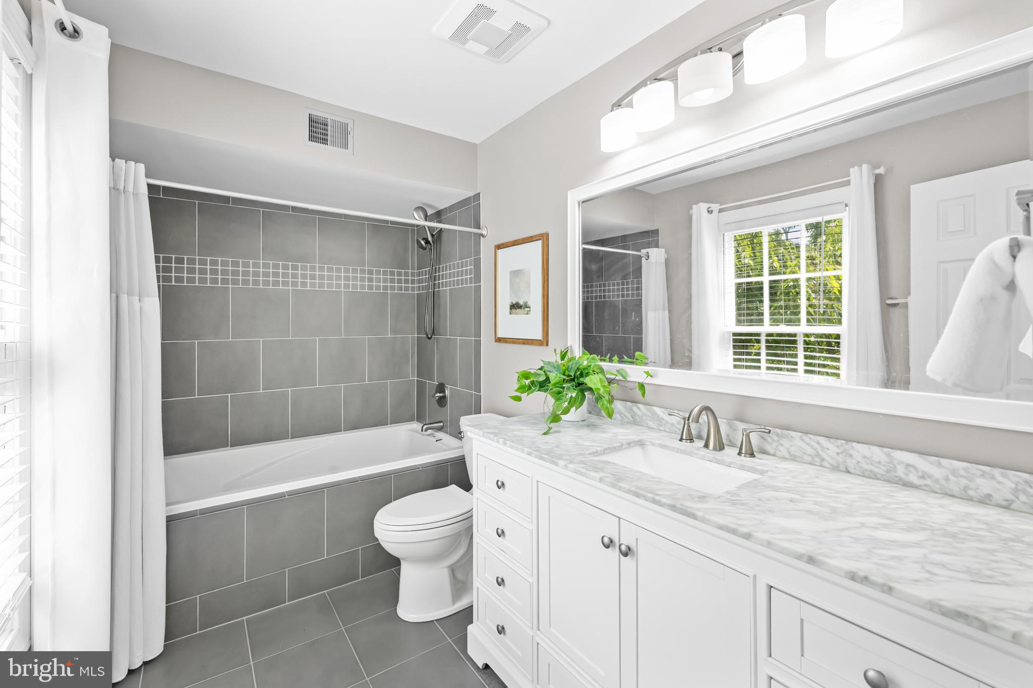 17045 Islip Loop, Unit 303 Dumfries, VA 22026 - Photo 23 of 48 a bathroom with a granite countertop tub a sink and a large window