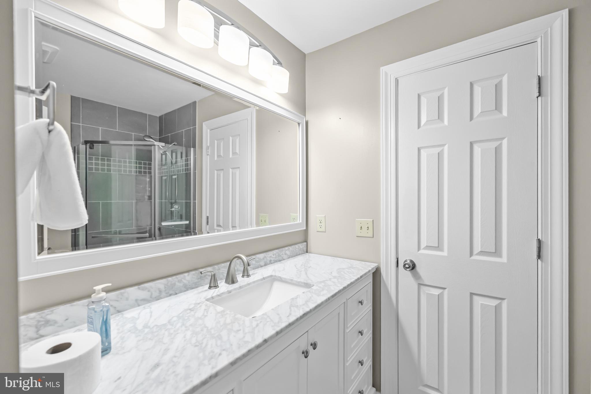 17045 Islip Loop, Unit 303 Dumfries, VA 22026 - Photo 36 of 48 a bathroom with a granite countertop sink and a mirror