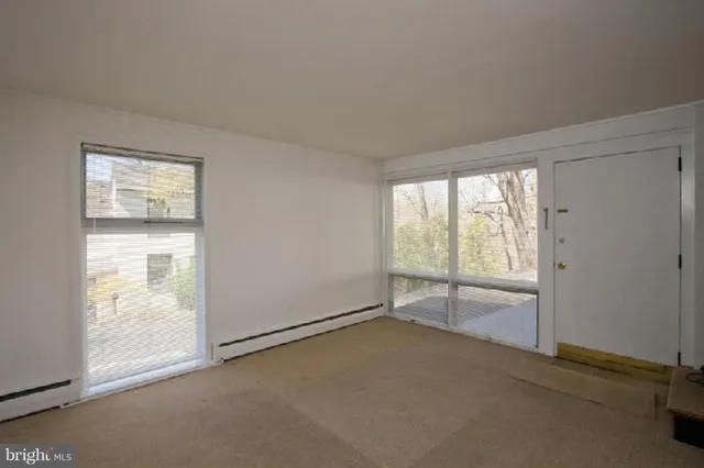 a view of a kitchen with a sink and an empty room