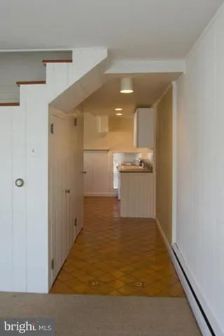 a kitchen with granite countertop a sink a stove a refrigerator and white cabinets