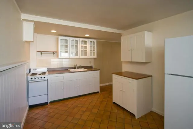 a view of a kitchen with an empty room and a window