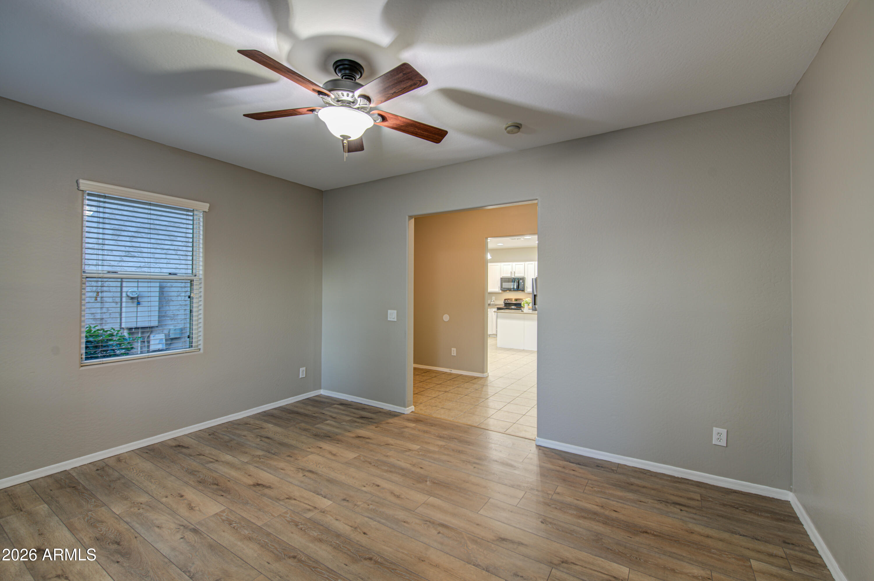 7759 West Monte Vista Road Phoenix, AZ 85035 - Photo 7 of 43 a view of an empty room with wooden floor and a window