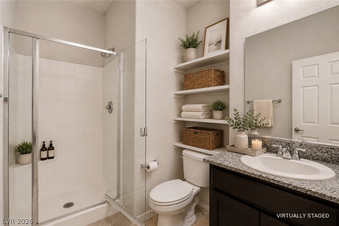 2185 Rio Rancho Pointe Place Henderson, NV 89002 - Photo 14 of 17 A well-appointed bathroom offers a glass-enclosed shower and a vanity with stone counters.