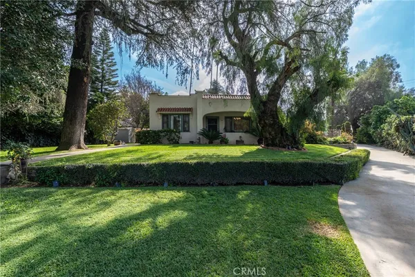a view of a house with a big yard with plants and trees