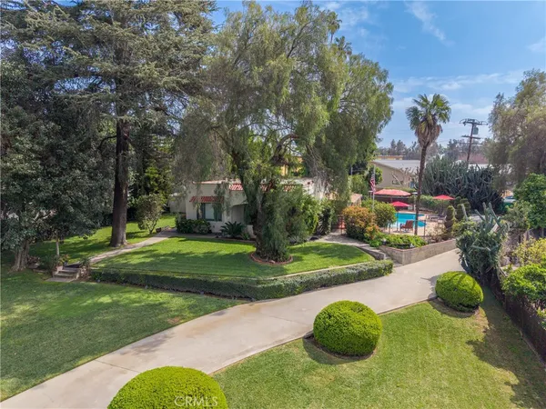 an aerial view of a house with swimming pool garden and trees