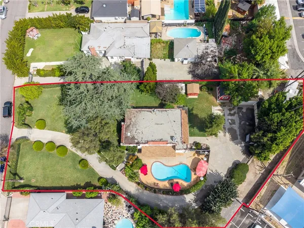 an aerial view of a house with a garden and lake view
