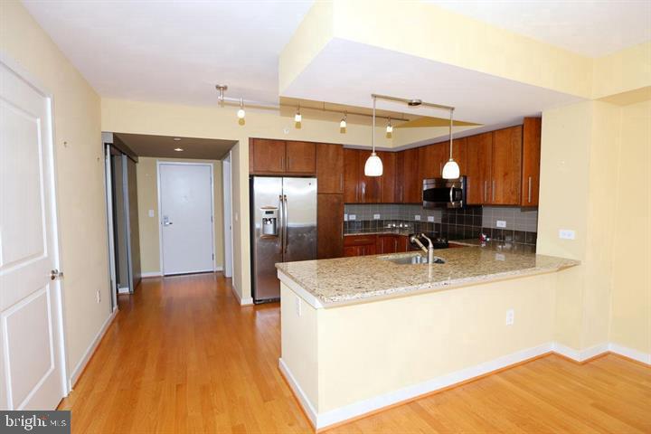 1025 First Street Southeast, Unit 1012 Washington, DC 20003 - Photo 2 of 22 a view of a kitchen with a sink dishwasher kitchen view with a dining table and chairs