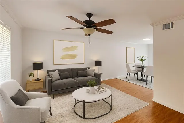 a living room with furniture and a wooden floor