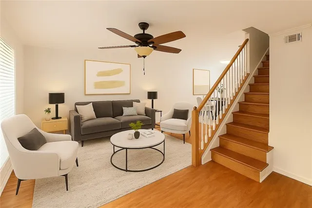 a living room with furniture and a ceiling fan