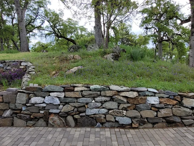 a backyard of a house with table and chairs under an umbrella