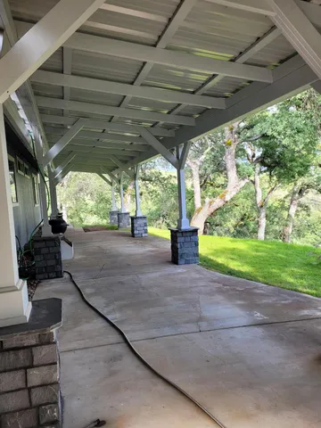 a backyard of a house with a large tree