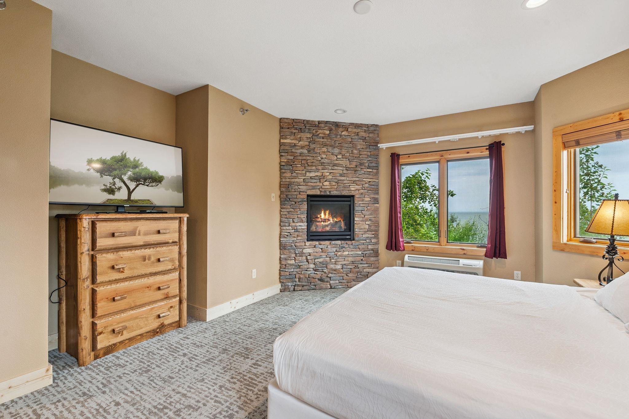 Two Burlington Road, Unit 5102 Two Harbors, MN 55616 - Photo 11 of 30 Bedroom featuring carpet flooring, multiple windows, a fireplace, baseboard heating, and recessed lighting