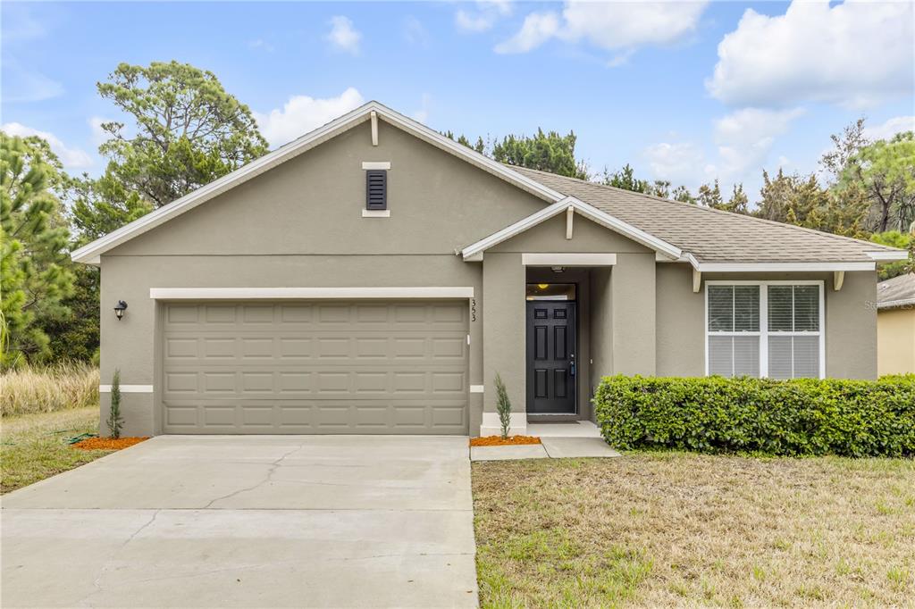 353 Admiralty Court Edgewater, FL 32141 - Photo 1 of 56 a front view of a house with a yard and garage