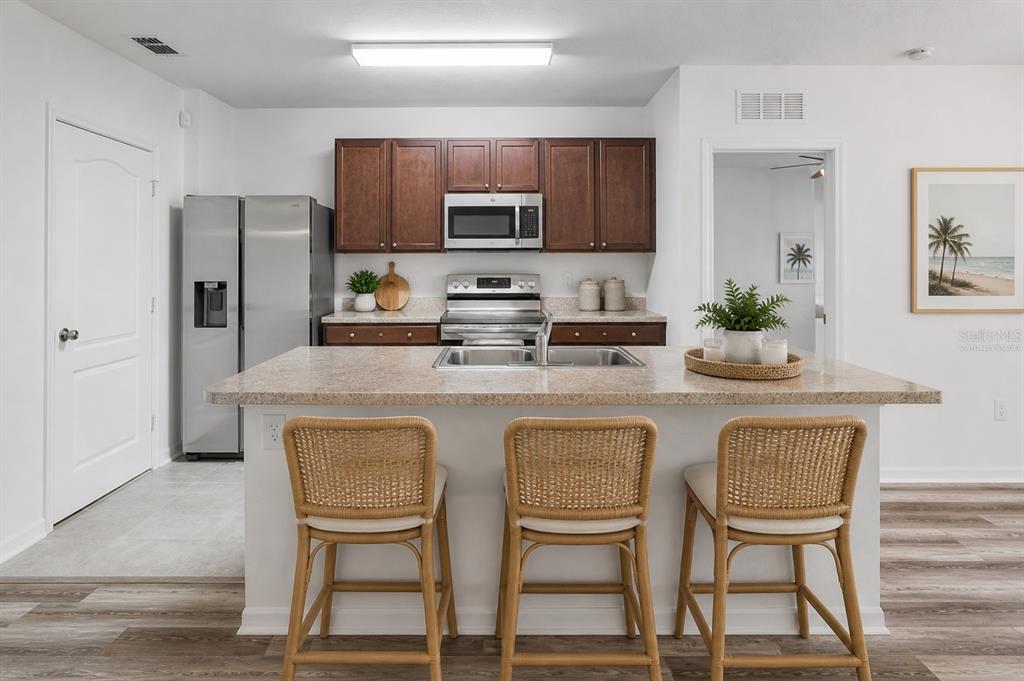 353 Admiralty Court Edgewater, FL 32141 - Photo 16 of 56 a kitchen with kitchen island a dining table chairs cabinets and stainless steel appliances