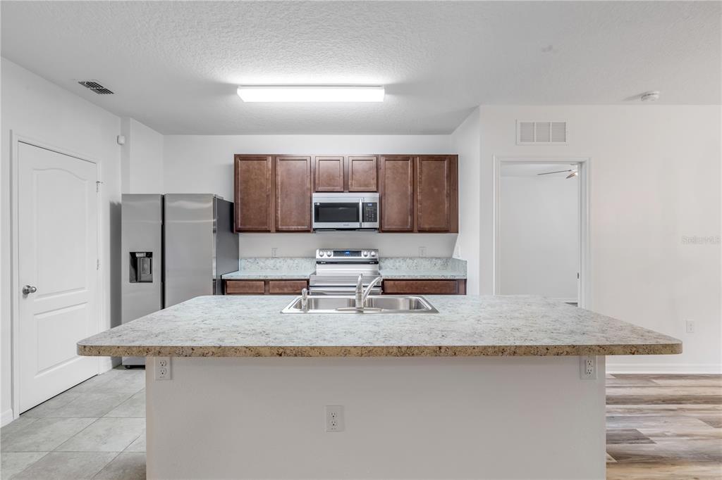 353 Admiralty Court Edgewater, FL 32141 - Photo 17 of 56 a kitchen with stainless steel appliances granite countertop a sink stove and refrigerator