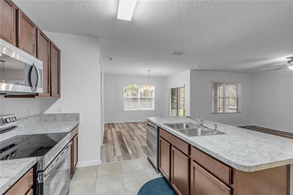 353 Admiralty Court Edgewater, FL 32141 - Photo 19 of 56 a kitchen with granite countertop a sink and a stove