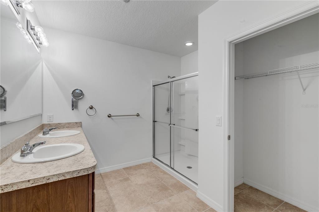 353 Admiralty Court Edgewater, FL 32141 - Photo 25 of 56 a bathroom with a granite countertop sink a mirror and shower