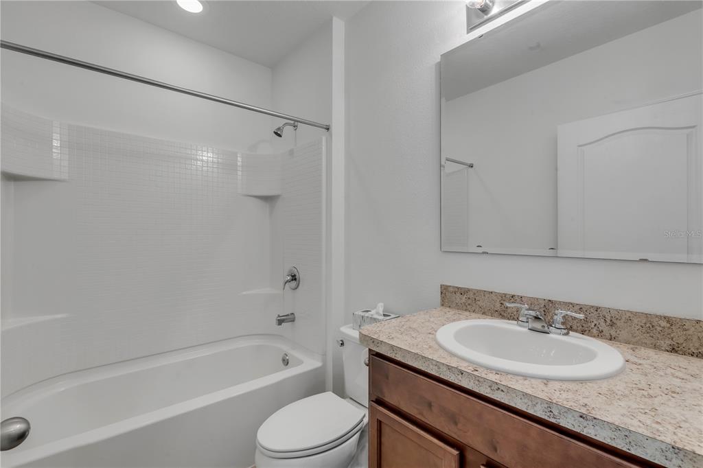 353 Admiralty Court Edgewater, FL 32141 - Photo 29 of 56 a bathroom with a granite countertop sink a toilet and shower