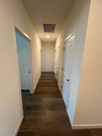 a view of a hallway with wooden floor
