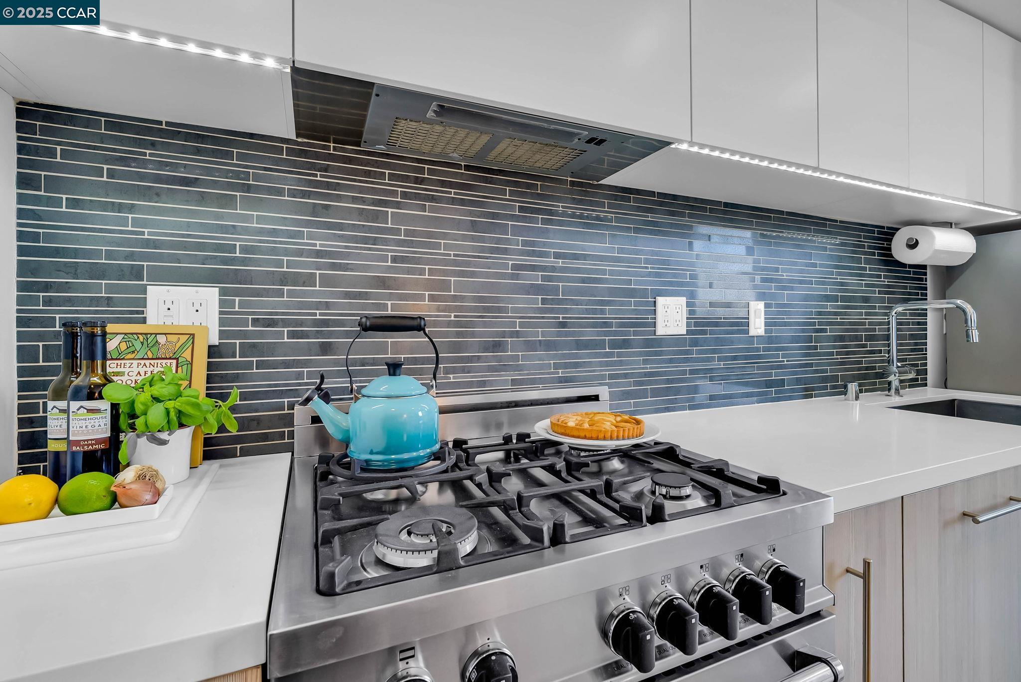 1515 15th Street, Unit 501 San Francisco, CA 94103 - Photo 12 of 46 a kitchen with stainless steel appliances a table chairs and a stove top oven