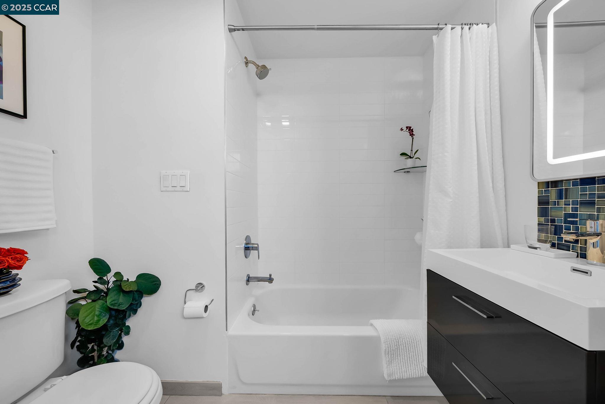 1515 15th Street, Unit 501 San Francisco, CA 94103 - Photo 20 of 46 a bathroom with a shower sink vanity mirror and toilet