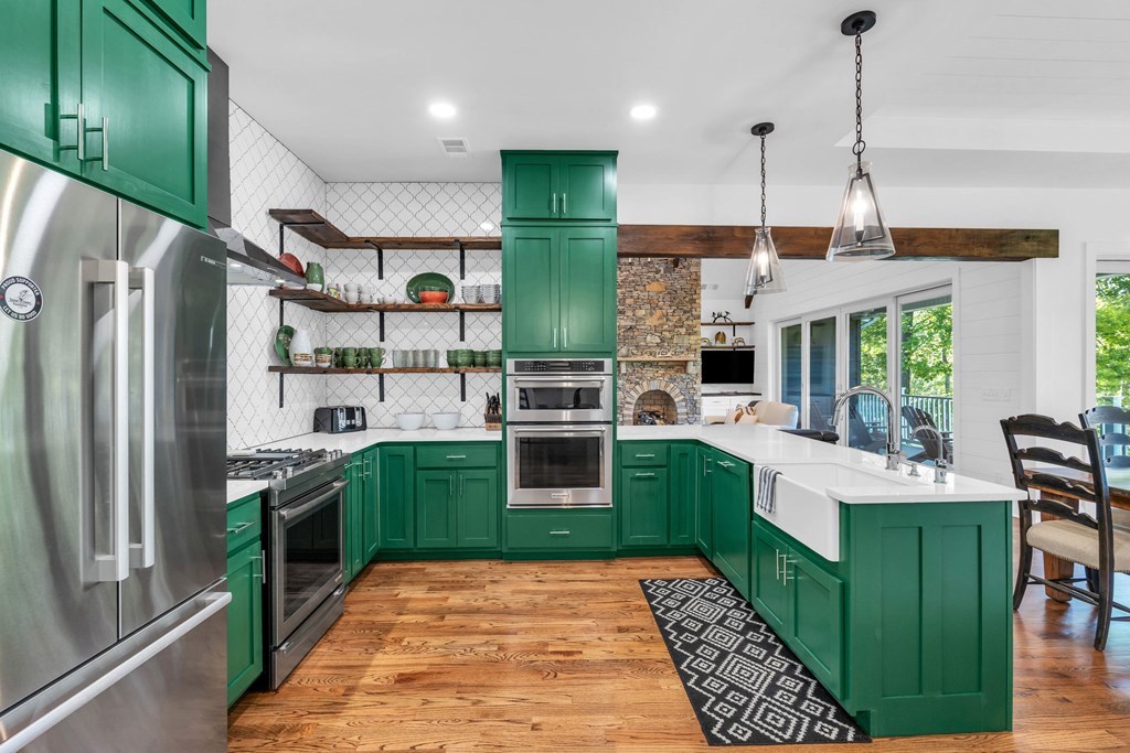 703 Cherokee Hill Road Hiawassee, GA 30546 - Photo 5 of 23 a kitchen with stainless steel appliances granite countertop a refrigerator a sink dishwasher a oven with a dining table and chairs