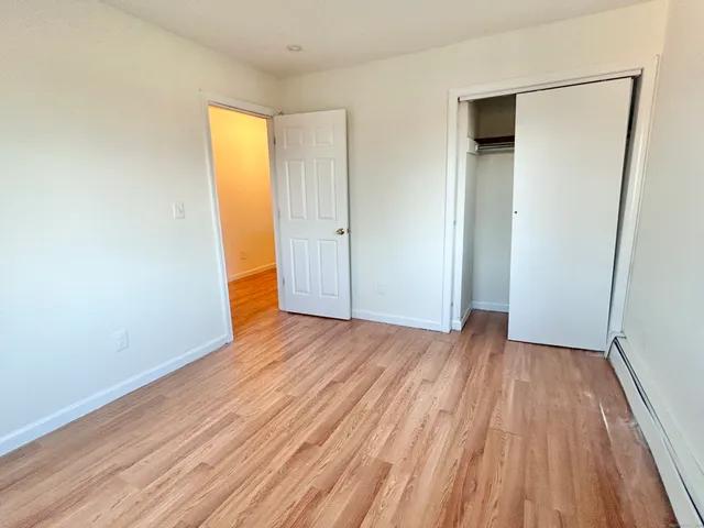 a view of a room with wooden floor and bench