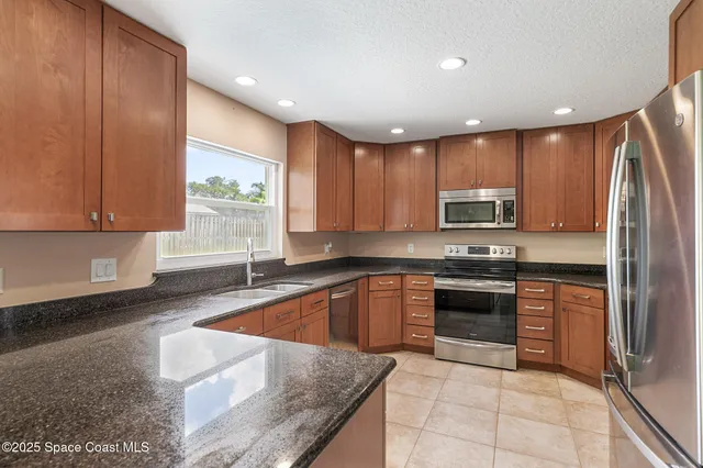 a kitchen with stainless steel appliances granite countertop a stove a sink and a microwave