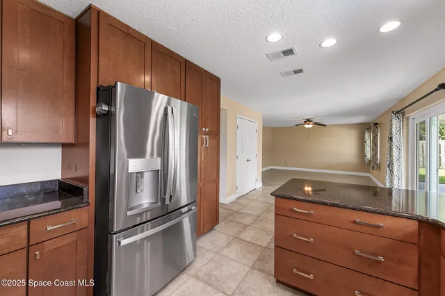 a kitchen with granite countertop stainless steel appliances and refrigerator