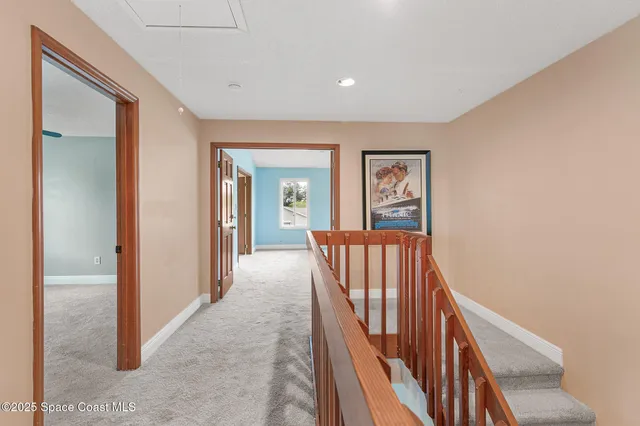 a view of a hallway with wooden floor and stairs