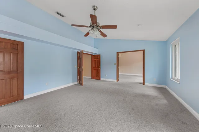 a view of empty room with ceiling fan