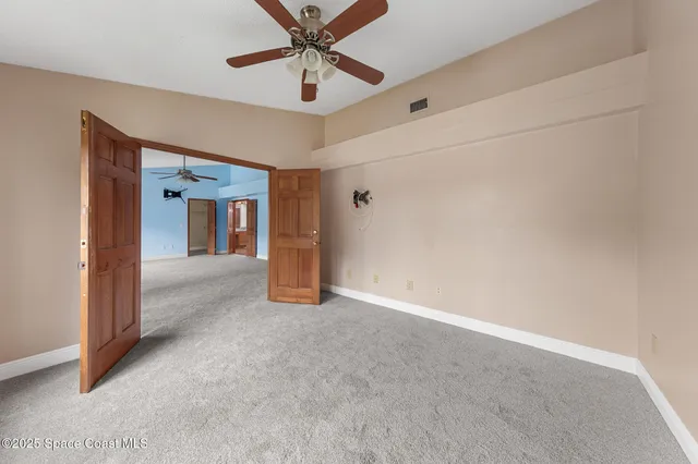 an empty room with chandelier fan