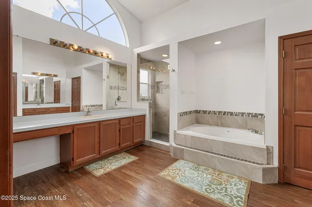 a spacious bathroom with a tub a sink and mirrors