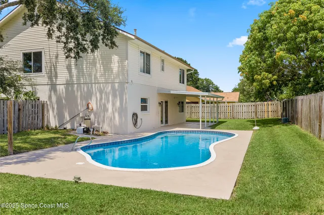 a view of a white house with a swimming pool