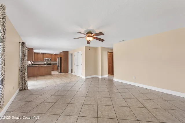 a view of an empty room with a ceiling fan