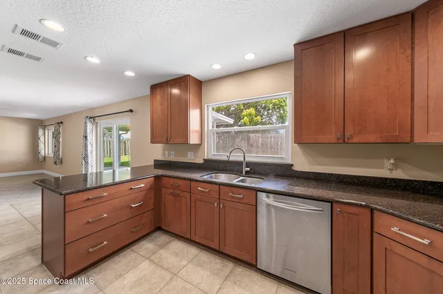 a kitchen with granite countertop a sink and cabinets