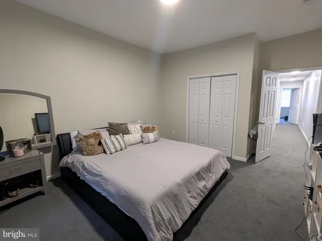 a bedroom with bed and a flat tv screen on a dresser