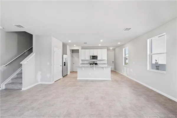 a view of a kitchen with kitchen island and living room