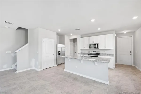 a kitchen with stainless steel appliances kitchen island sink refrigerator and stove