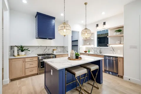 a kitchen with a stove a sink a dining table and chairs