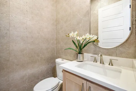 a bathroom with a sink a toilet and mirror