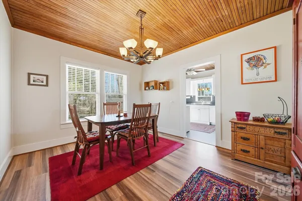 a view of a dining room with furniture a chandelier and wooden floor