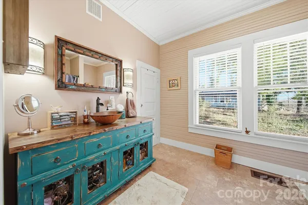 a bathroom with a sink mirror and a window