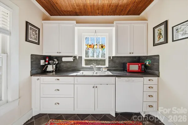 a kitchen with white cabinets and black appliances