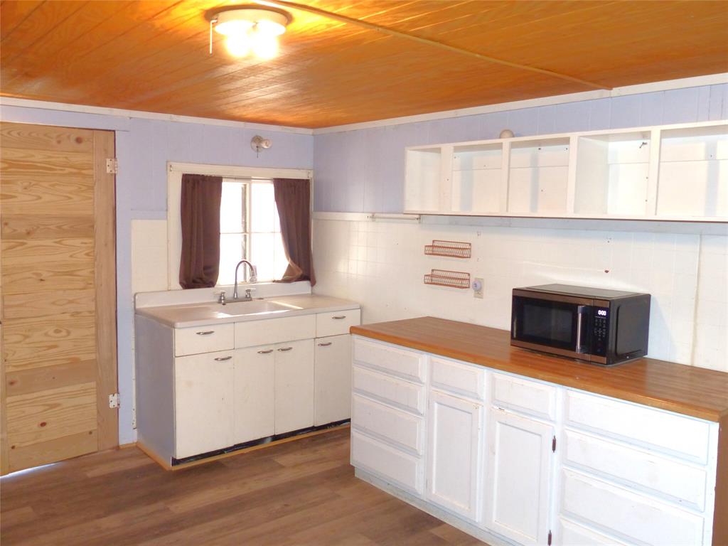 286 North Fm 1851 Voca, TX 76887 - Photo 14 of 23 Kitchen featuring wood ceiling, wood finished floors, open shelves, and a sink