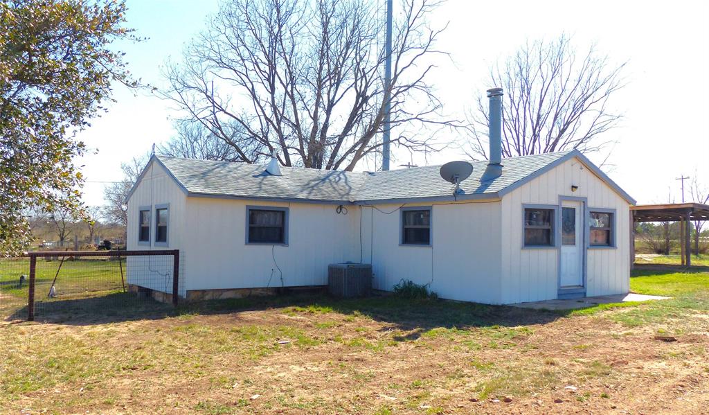 286 North Fm 1851 Voca, TX 76887 - Photo 2 of 23 Rear view of property featuring central AC, a yard, and roof with shingles